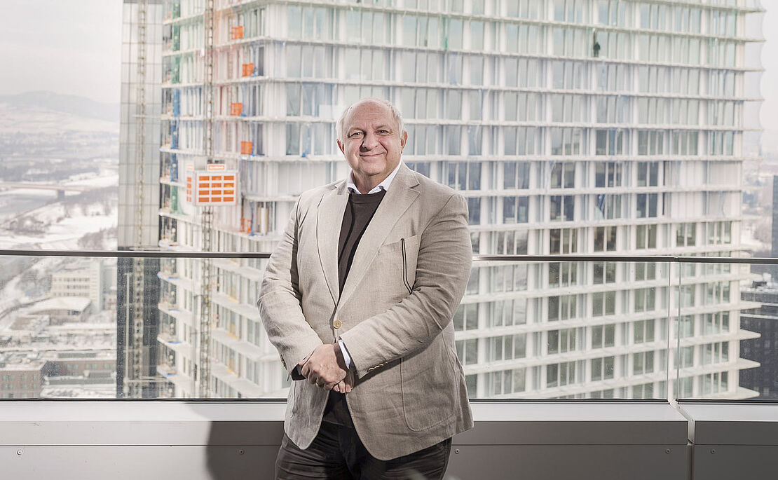 Wolfdieter Jarisch in einem Hochhaus, dahinter der im Bau befindliche DC Tower 2