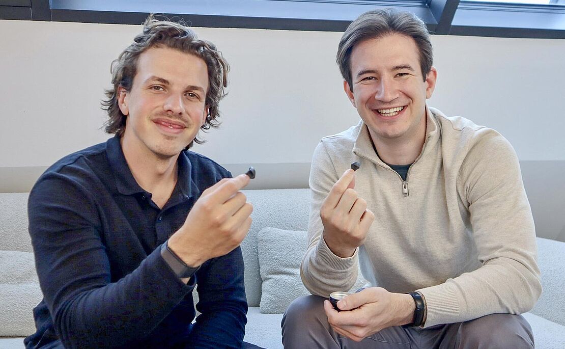 Léon Can Aricioglu und Markus Hirzberger mit je einem Ohrstöpsel in den Fingern