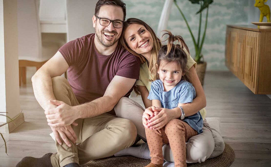 Foto von jungen Eltern mit einem kleinen Kind am Schoß