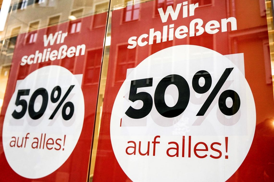 Foto von Plakaten mit der Aufschrift "Wir schließen. 50% auf alles!"