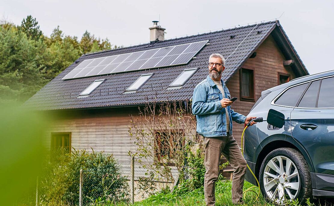 Mann beim Aufladen seines Autos