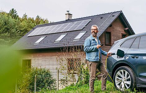 Mann beim Aufladen seines Autos