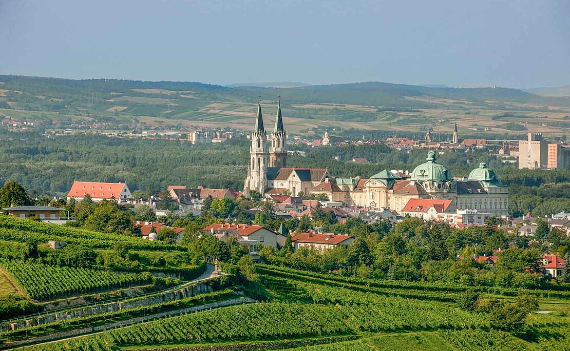 Landschaftsaufnahme mit Stift Klosterneuburg mit Feldern und Hügeln