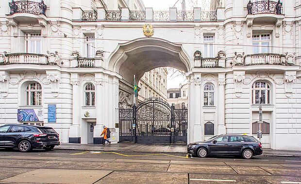 Zwei Zinshäuser, mit einem Durchgang verbunden, darauf eine Terrasse, im Durchgang ein schmiedeeisernes Tor