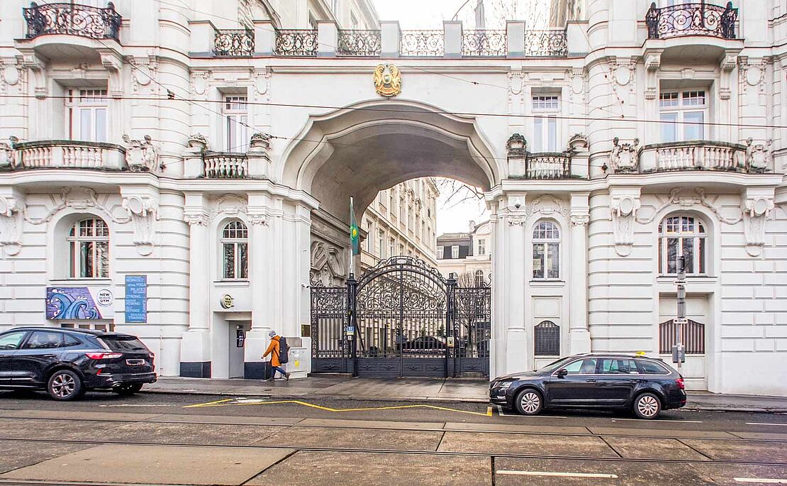 Zwei Zinshäuser, mit einem Durchgang verbunden, darauf eine Terrasse, im Durchgang ein schmiedeeisernes Tor