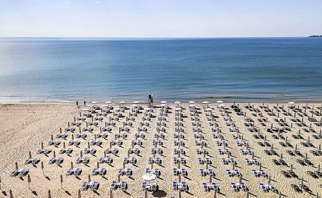 Meer und großer Strand mit hunderten von Liegen und Sonnenschirmen