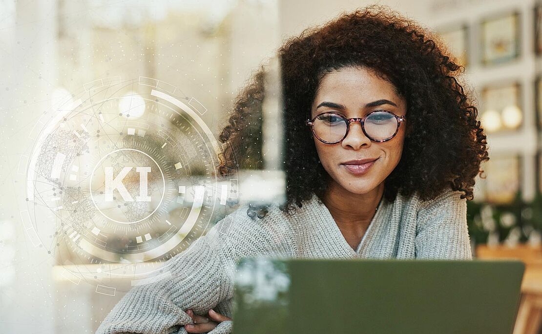 Frau, die vor einem Laptop sitzt und ein rundes Symbol mit den Buchstaben KI