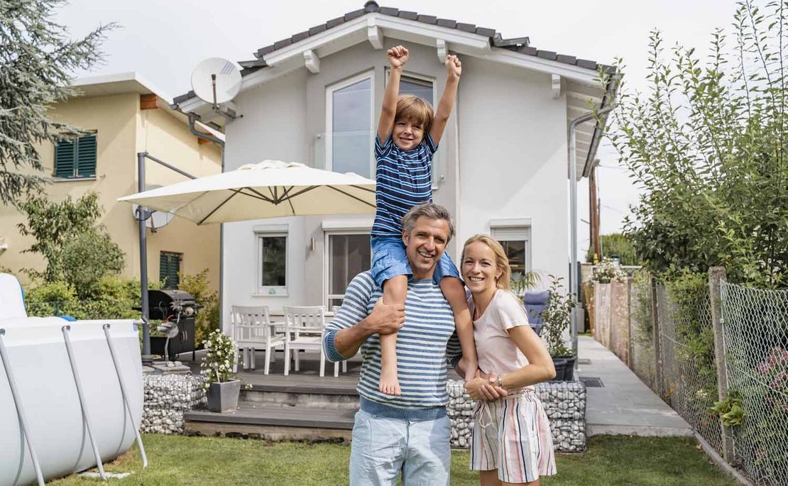 Vater, Mutter und Kind vor ihrem Haus