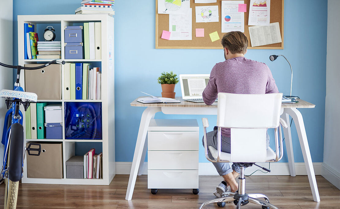 Mann sitzt am Schreibtisch im Homeoffice