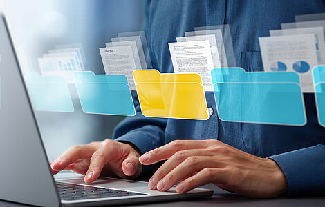 Zwei Hände auf einer Tastatur, darüber gelegt mit einem Bildbearbeitungsprogramm Ordner-Icons