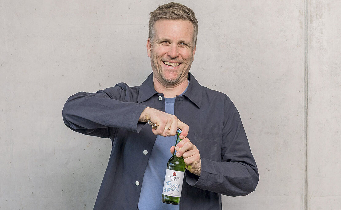 Josef Sigl beim Öffnen eines Trumer Pils