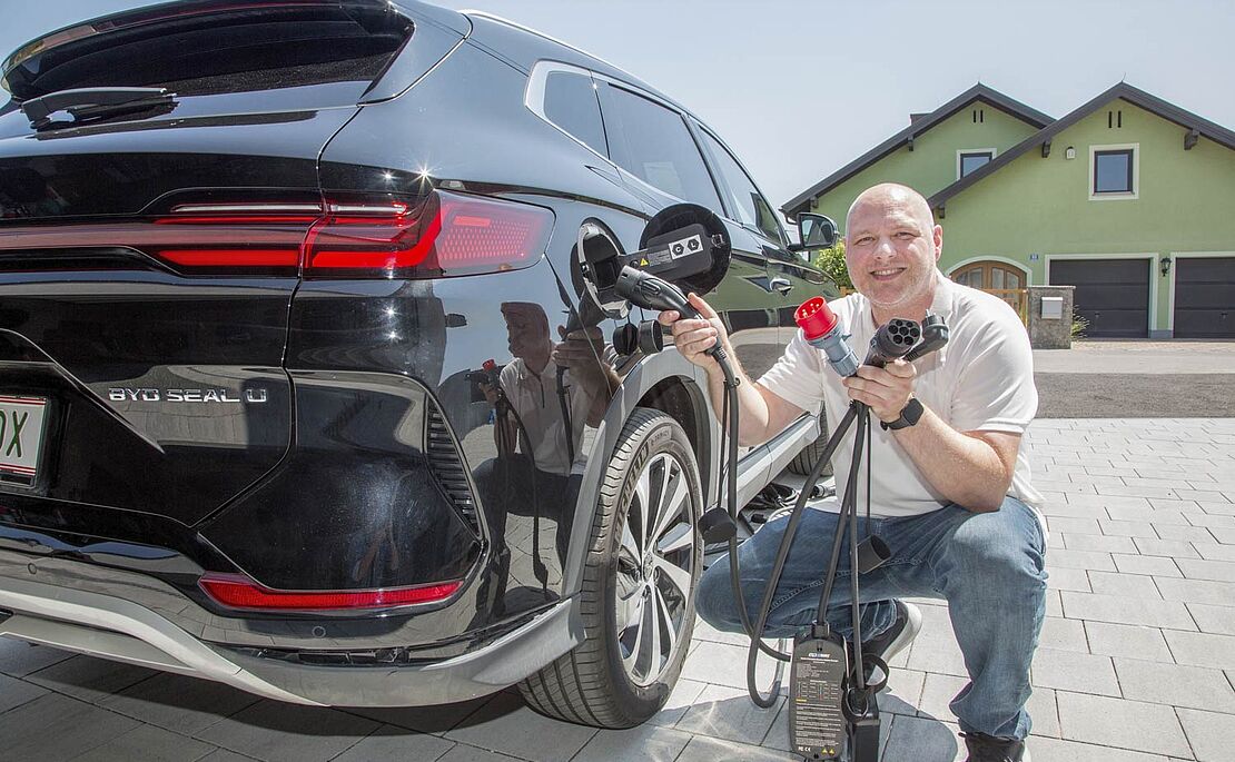 Markus Schellner kniend vor seinem Auto