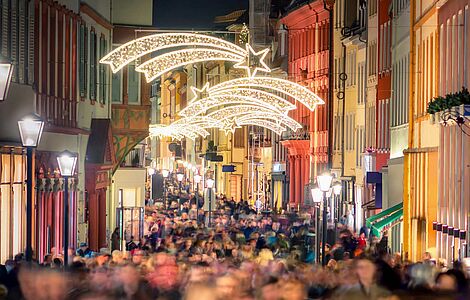 Blick auf eine gefüllte Einkaufsstraße mit Weihnachtsbeleuchtung