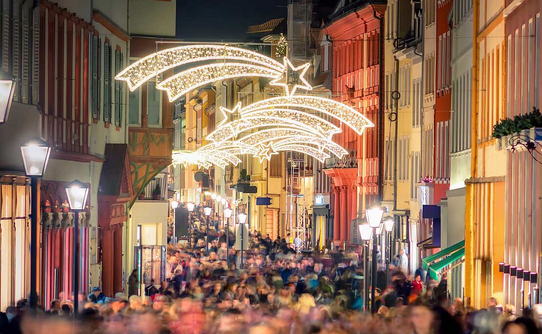 Blick auf eine gefüllte Einkaufsstraße mit Weihnachtsbeleuchtung