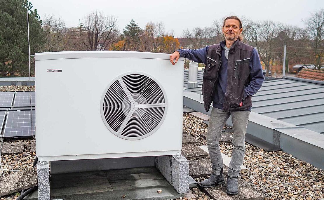 Steinmetz Markus Peche mit seiner Wärmepumpe am Dach