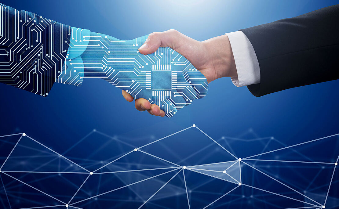 Handshake einer KI-generierten Hand und menschlicher Hand