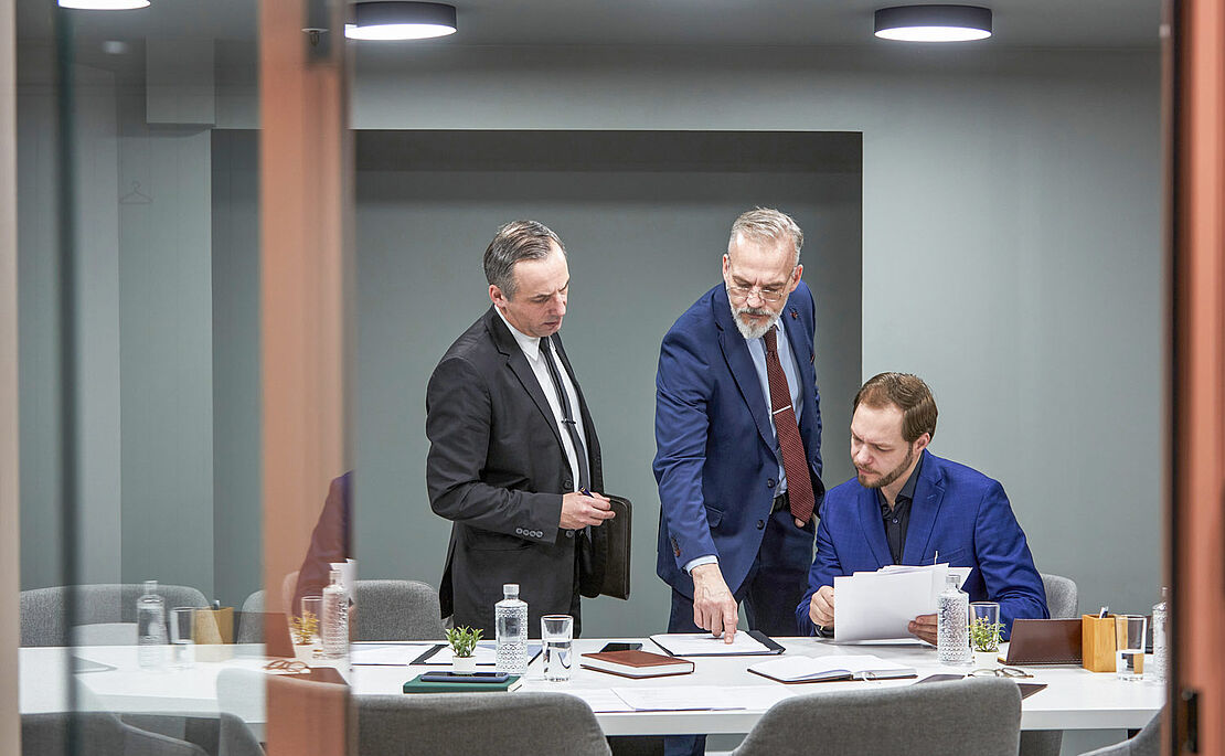 Drei Männer im Anzug im Gespräch