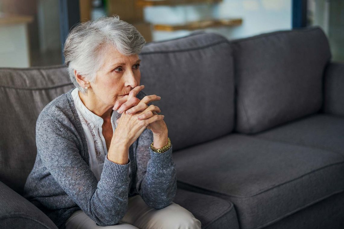 alte Frau sitzend am Sofa