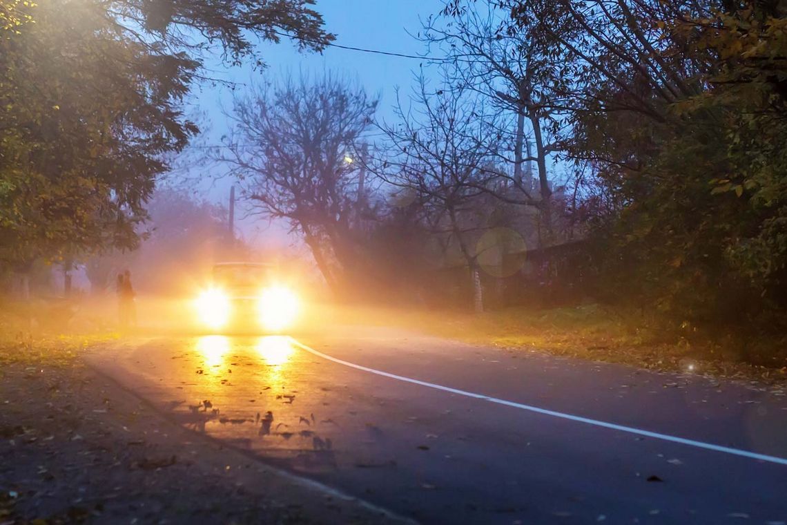 Auto bei Nacht mit aufgeblendetem Licht